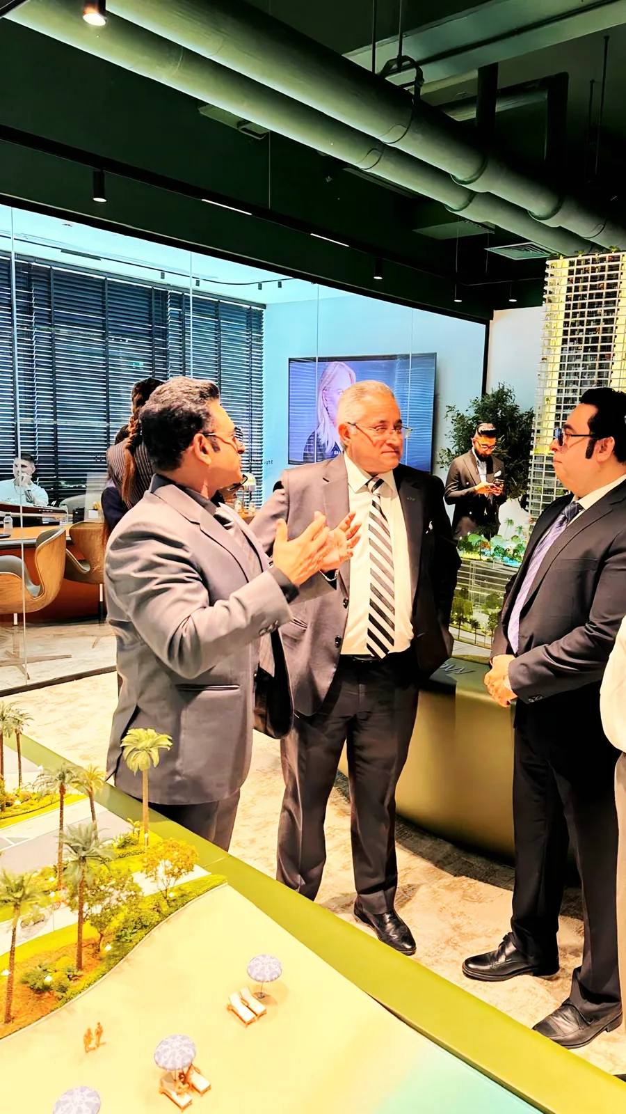 AlixirNova team reviewing a property scale model with a client at a Dubai developer sales gallery